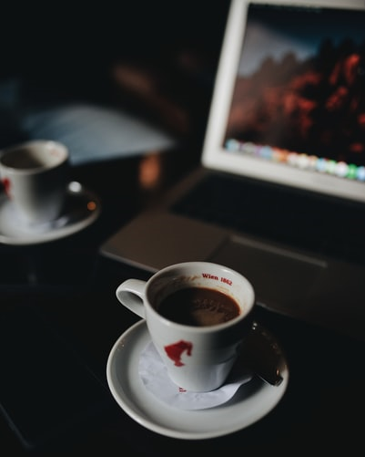 Coffee cup in front of laptop on a desk